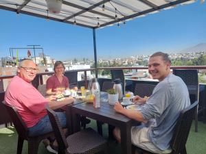 阿雷基帕Lonko Hostel Arequipa的一群人坐在桌旁吃饭