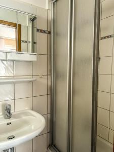 ein Bad mit einer Dusche und einem Waschbecken in der Unterkunft Haus Tida in Norderney