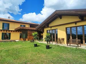 a house with a bench in the yard at Casale del Valla Agri B&B Naturista in Spigno Monferrato