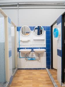 a bathroom with two sinks and two mirrors at Leisure Hostel in Krabi