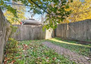a backyard with a wooden fence and a sidewalk at Crown Heights Charmer with private backyard access in Brooklyn