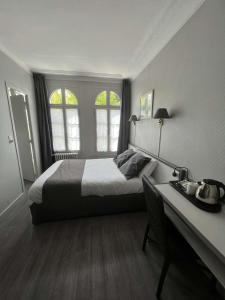 ルーアンにあるオテル セリーヌ - オテル ドゥ ラ ガールのベッドルーム1室(ベッド1台、デスク、窓2つ付)