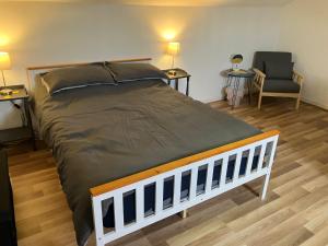 ein großes Bett in einem Zimmer mit 2 Tischen und einem Stuhl in der Unterkunft Bells Yard cottage in Maryport