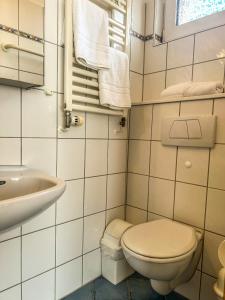 ein weißes Bad mit einem WC und einem Waschbecken in der Unterkunft Haus Tida in Norderney