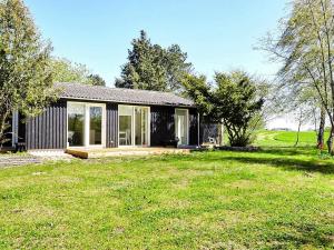 una pequeña casa negra con un gran patio en Holiday home Holbæk III en Holbæk