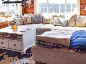ein Wohnzimmer mit einem Sofa und einem Tisch in der Unterkunft Holiday home HURDAL II in Hurdal