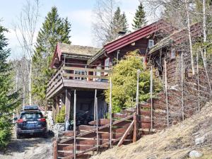 een auto geparkeerd voor een blokhut bij Holiday home HURDAL II in Hurdal