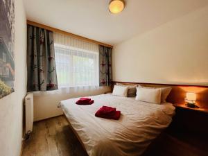 ein Schlafzimmer mit einem Bett mit zwei roten Kissen darauf in der Unterkunft Ferienwohnung Buchau in Fieberbrunn