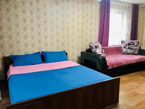 a bedroom with a bed and a couch at Apartaments in the city center in Karagandy +5 photos
