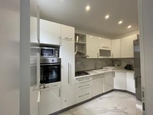 a white kitchen with white cabinets and appliances at Alegro in Mostar