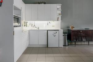 een witte keuken met een koelkast en een magnetron bij Hera 0101 in Koksijde