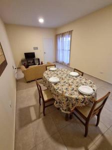 mesa de comedor con 4 sillas y sala de estar en Hermoso departamento en Mendoza en Godoy Cruz