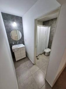 y baño con lavabo, espejo y aseo. en Hermoso departamento en Mendoza en Godoy Cruz