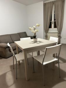 uma mesa branca e cadeiras numa sala de estar com um sofá em Appartamento Eugenio em Colico