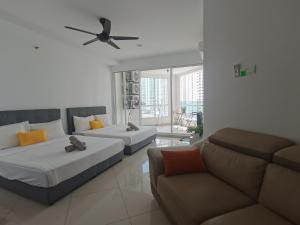 a living room with two beds and a couch at Family Suites at Mansion One by MAJ in George Town