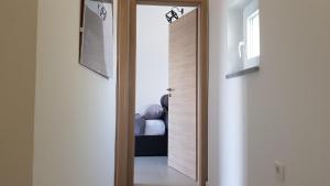 une porte menant à une chambre avec un lit dans l'établissement Apartman Nagy, à Dramalj