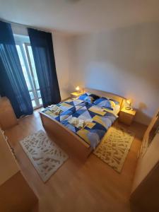 1 dormitorio con cama con sábanas azules y ventana en Apartman Benat en Stolac