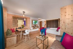 Habitación de hotel con cama y zona de comedor. en Impuls Hotel Tirol, en Bad Hofgastein