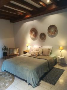 - une chambre avec un grand lit et 2 assiettes murales dans l'établissement Le Baron Perché, à Saint-Cyprien