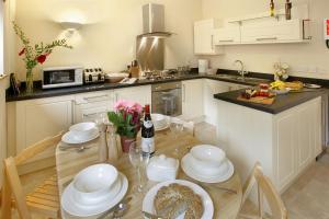 una cocina con una mesa con platos y copas de vino en Meadow Byre en Little Dean