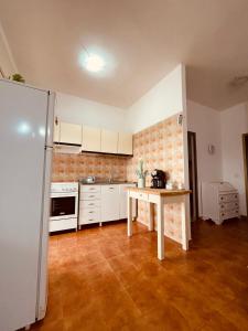 een keuken met een koelkast en een tafel. bij Appartamento di Egidio in San Pasquale