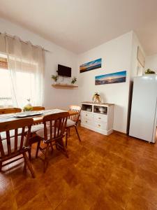 cocina con mesa, sillas y nevera en Appartamento di Egidio, en San Pasquale