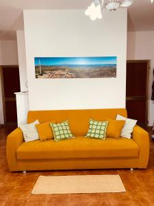 un sofá amarillo con almohadas en la sala de estar en Appartamento di Egidio, en San Pasquale