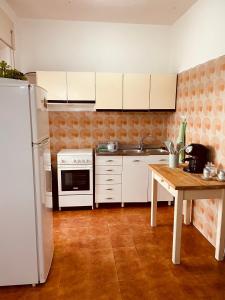 een keuken met witte apparatuur en een houten tafel bij Appartamento di Egidio in San Pasquale