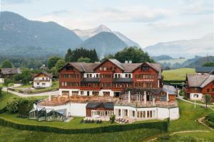 an aerial view of a large house in the mountains at MONDI Hotel am Grundlsee in Grundlsee