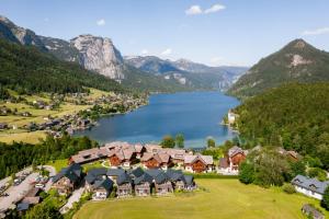 eine Luftansicht eines Resorts mit See und Bergen in der Unterkunft MONDI Hotel am Grundlsee in Grundlsee