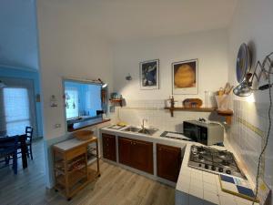a kitchen with a sink and a stove top oven at Casa relax tra cielo e mare in Bosa