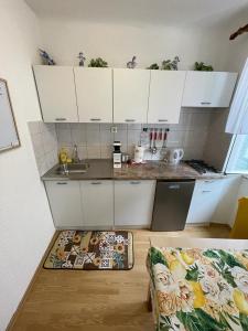 a kitchen with white cabinets and a counter top at Đana in Cres