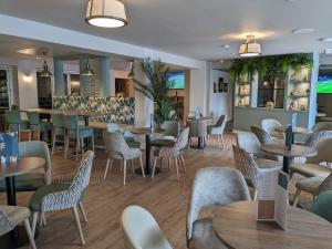 un restaurante con mesas y sillas y un bar en Shorefield Country Park Self-Catering Holiday Home, en Lymington