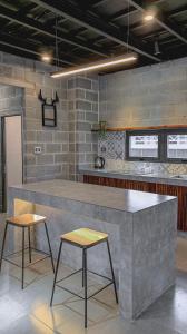 een keuken met een aanrecht en 2 krukken in een kamer bij C.House - Villa Homestay Long Hải in Ấp Lò Vôi
