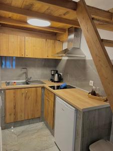 una cocina con armarios de madera y fregadero en Pinelopi’s House, en Porto Koufo