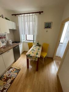 a kitchen with a table and yellow chairs in a room at Đana in Cres