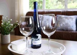 a bottle of wine and two wine glasses on a table at A Casa da bisavoa in Sanxenxo
