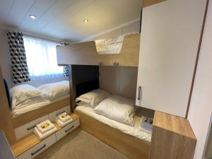 a room with two bunk beds in it at Luxury Lakeside Lodge with HTub Beautiful Views in Annan