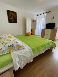 a bedroom with a large bed with a green blanket at Đana in Cres