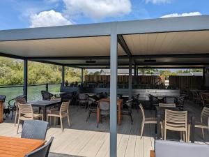 a patio with tables and chairs and a bar at Chichester Lakeside Self-Catering Holiday Home in Chichester