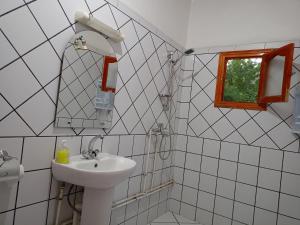 a bathroom with a sink and a mirror and a window at HôteL Berbère de la Montagne in Imdiazene