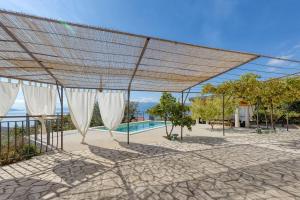 a patio with white curtains and a swimming pool at Apartment Happy sound in Rijeka