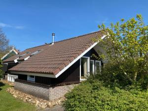 een huis met een bruin dak bij Haantjes Vakantiepark in Formerum