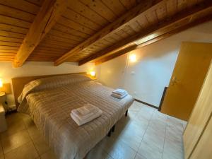 a bedroom with a bed with two towels on it at Lory apartment in Bardolino
