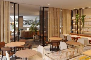 a restaurant with tables and chairs and a counter at Four Points by Sheraton Matosinhos in Matosinhos