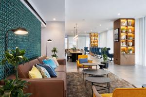 a lobby with a couch and chairs and a table at Four Points by Sheraton Matosinhos in Matosinhos