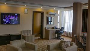 un soggiorno con 2 sedie e un soggiorno con TV di Holiday Hotel Addis Ababa ad Addis Abeba