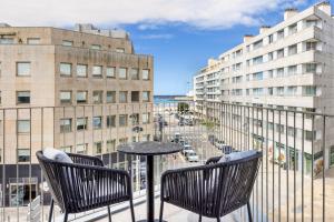 a table and chairs on a balcony with buildings at Four Points by Sheraton Matosinhos in Matosinhos