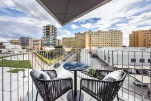 a balcony with a table and chairs and a city at Four Points by Sheraton Matosinhos in Matosinhos