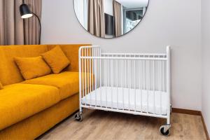 a living room with a yellow couch and a mirror at Four Points by Sheraton Matosinhos in Matosinhos